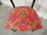 a red chair with a gold and black pattern on it