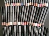 une pile de crayons de maquillage empilés les uns sur les autres