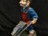 a figurine of a man with a wheelbarrow holding a wheelbarrow
