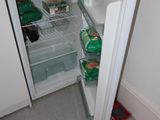 an open refrigerator in a small kitchen with a lot of food in it