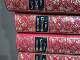 several pink books stacked on top of each other on a table