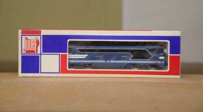 a blue and red train in a box on a table