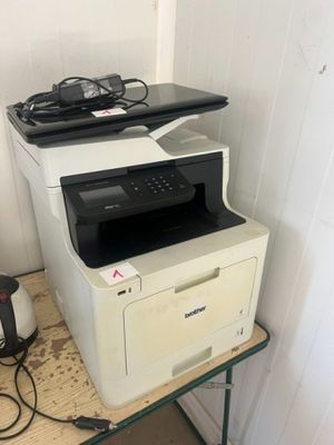 une imprimante blanche posée sur une table en bois