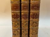 un ensemble de quatre livres anciens en cuir avec des couvertures dorées et rouges
