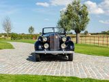 a black antique car parked on a cobblestone road