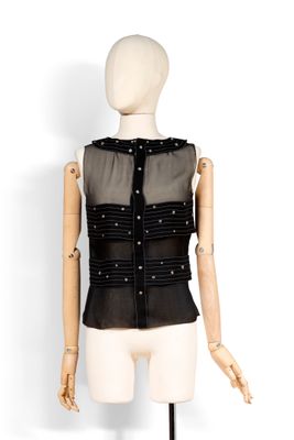 haut noir transparent avec encolure ornée de perles, présenté sur un mannequin