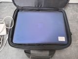 a blue laptop in a black case on the floor