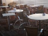 many tables and chairs that are outside of a building