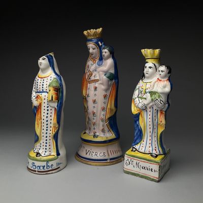 trois figurines représentant des femmes vêtues de couleurs et de motifs différents