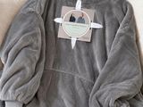 un sweat à capuche gris posé sur un canapé, avec une étiquette dessus