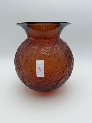 un vase en verre brun sur lequel est collée une étiquette rouge