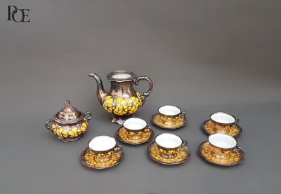 cinq tasses et une théière sur la table