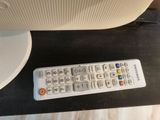 a remote control sitting on a table next to a computer monitor