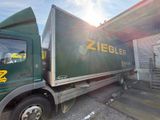a green truck that is parked in front of a building