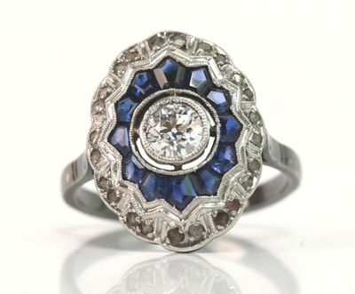 une image d'une bague en diamant et saphir sur fond blanc