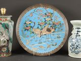 trois vases et une assiette posés sur une table
