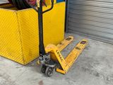 a fork lifter with a large stack of wheels in front of a garage door