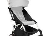the buggy stroller is white and black with a white seat