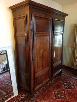 une grande armoire en bois dans le coin d'une pièce