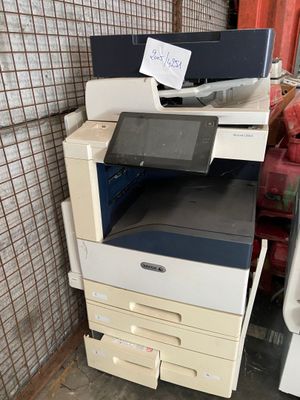 a stack of printer and scanners in a room