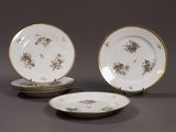 three plates with gold rims and flowers on them on a gray surface
