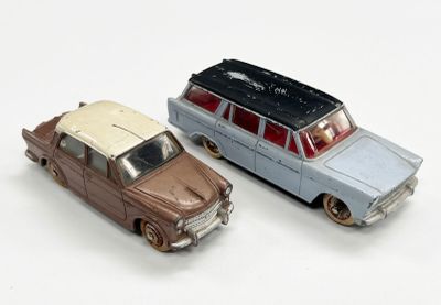 deux voitures jouets assises l'une à côté de l'autre sur une surface blanche