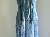 a dress on a mannequin stand in front of a window