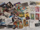 a lot of postcards on a bed with a white comforter