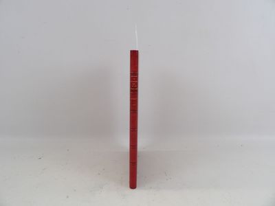 une bougie rouge avec un bougeoir qui en dépasse, posée sur une surface blanche