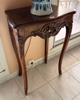 a table with a vase on top of it in front of a window
