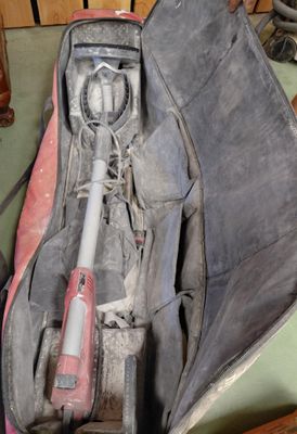 un sac posé par terre, contenant une batte de baseball