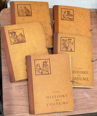 Quatre livres sont posés sur une table en bois, avec une tasse de café devant eux.