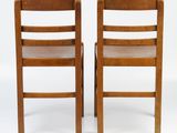 pair of wooden chairs with leather seats on each of them