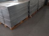 many stacks of white plates on a pallet in a warehouse