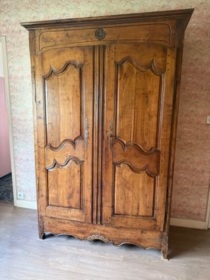 une grande armoire en bois dans le coin d'une pièce