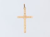 a gold cross pendant on a white background with a sky background