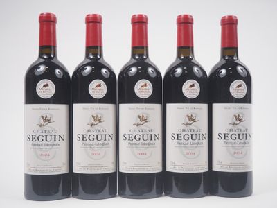 quatre bouteilles de vin rouge sont alignées