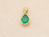 an image of a gold pendant with a green tear shaped stone