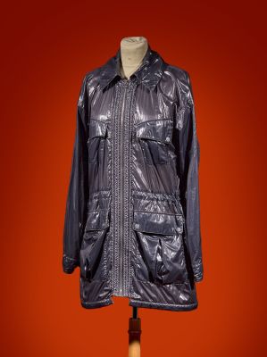 a black leather jacket on a mannequin stand against a red background