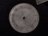 a silver clock that is sitting on a black surface