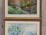 Deux tableaux représentant des arbres sont accrochés au mur d'une pièce.