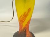 an image of a yellow and red glass lamp with a metal base