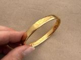 someone is holding a gold bang that has a ring on top of it