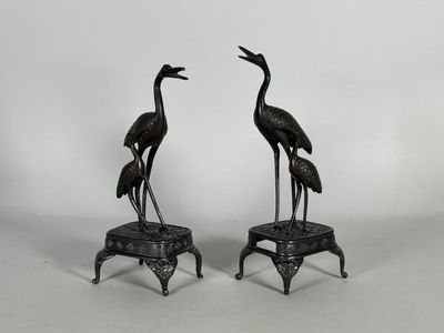 une paire de grues en bronze sur des socles