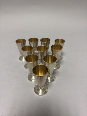 six coupes en argent sont alignées les unes à côté des autres sur une surface blanche
