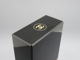 a close up of a black box with a gold logo on it