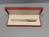 un gros plan d'un stylo dans une boîte rouge posée sur une table