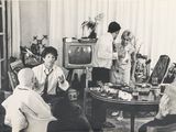 a black and white photo of a group of people in a living room