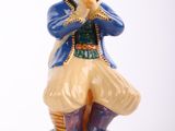 a figurine of a man sitting on a green base