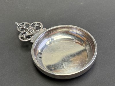 a small silver pocket watch with a key on it